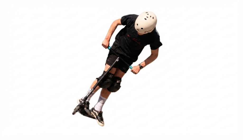 Person on a kick scooter mid-air, wearing a helmet and protective gear, performing a jump or trick.